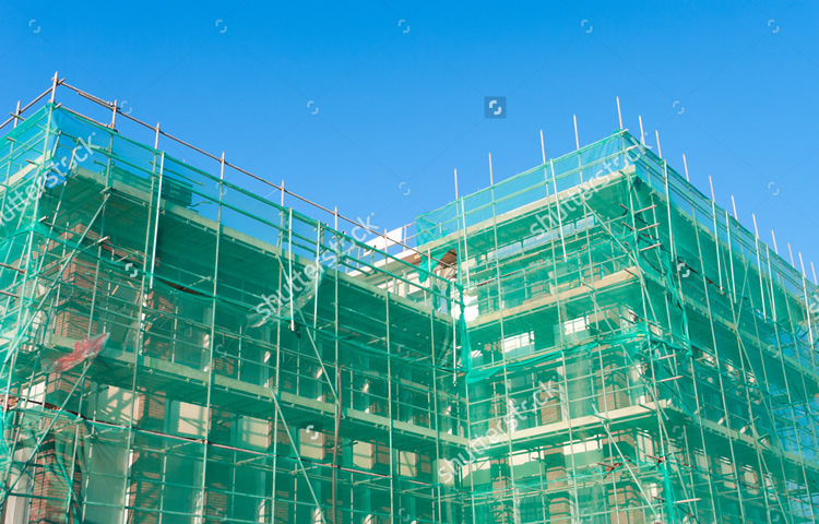 stock-photo-building-under-construction-wrapped-in-a-green-net-for-safety-97852178